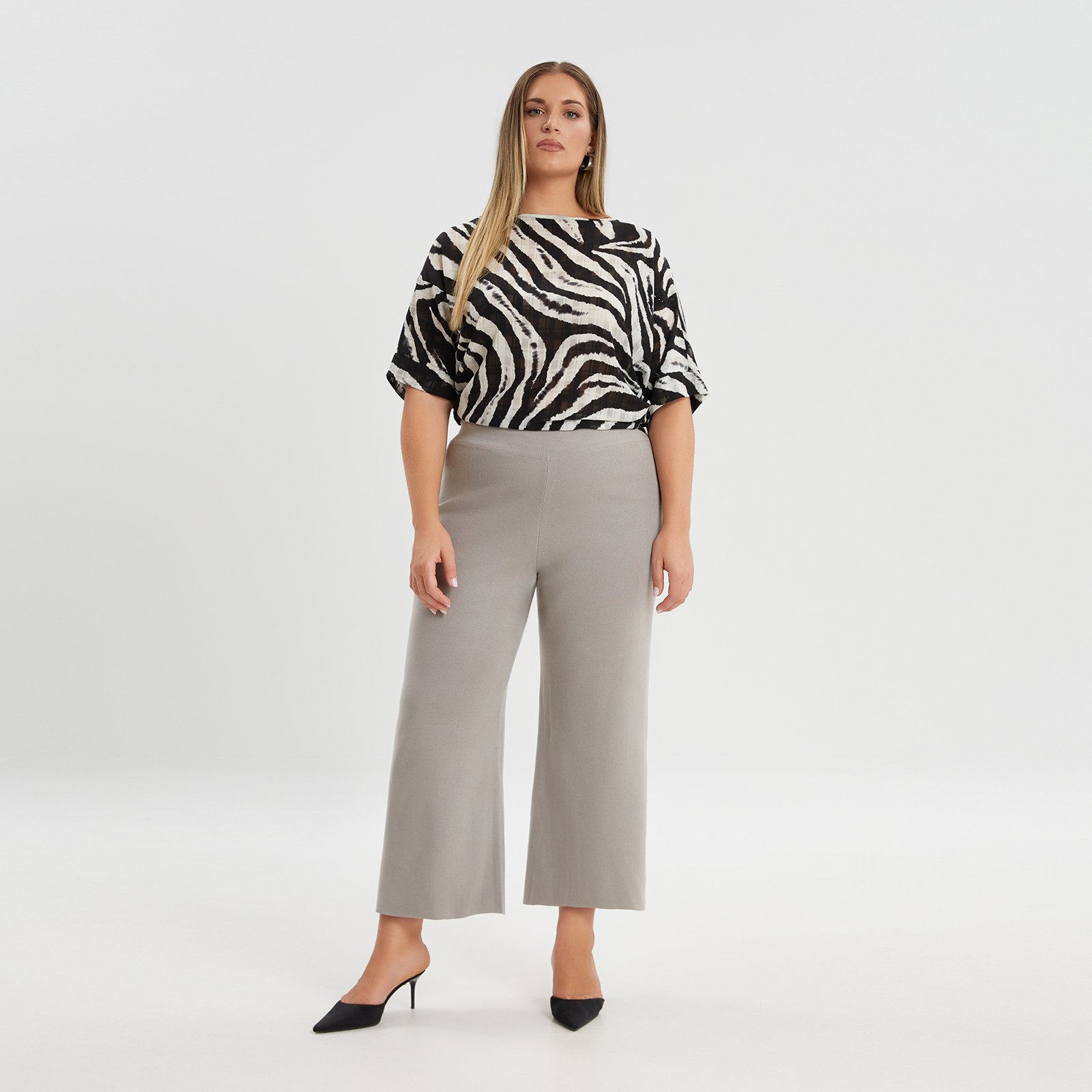 Μία τέτοια παντελόνα ζιπ κιλότ με απαλή πλέξη συνδυάζει άνεση και σύγχρονο στυλ με απόλυτη ευκολία. Η φαρδιά γραμμή προσφέρει ελευθερία κινήσεων και ένα κομψό, μοντέρνο look. Το απαλό πλεκτό ύφασμα προσθέτει μια πινελιά πολυτέλειας, καθιστώντας την κατάλληλη τόσο για καθημερινές όσο και για πιο επίσημες εμφανίσεις. Είτε την συνδυάσετε με μία κομψή μονόχρωμη μπλούζα για το γραφείο, είτε με ένα εντυπωσιακό zebra τοπ για night out, αυτή η ζιπ κιλότ είναι απαραίτητο κομμάτι για κάθε fashion-forward γκαρνταρόμπα. ● Μαλακό, λεπτό πλεκτό ύφασμα ● Ελαστική ζώνη στη μέση για άνεση ● Φαρδιά γραμμή τύπου culotte Μήκος: 96 εκ. 90%POLYACRYLIC 10%POLYESTER Το μοντέλο έχει ύψος 1,79 εκ. και φοράει O/S 