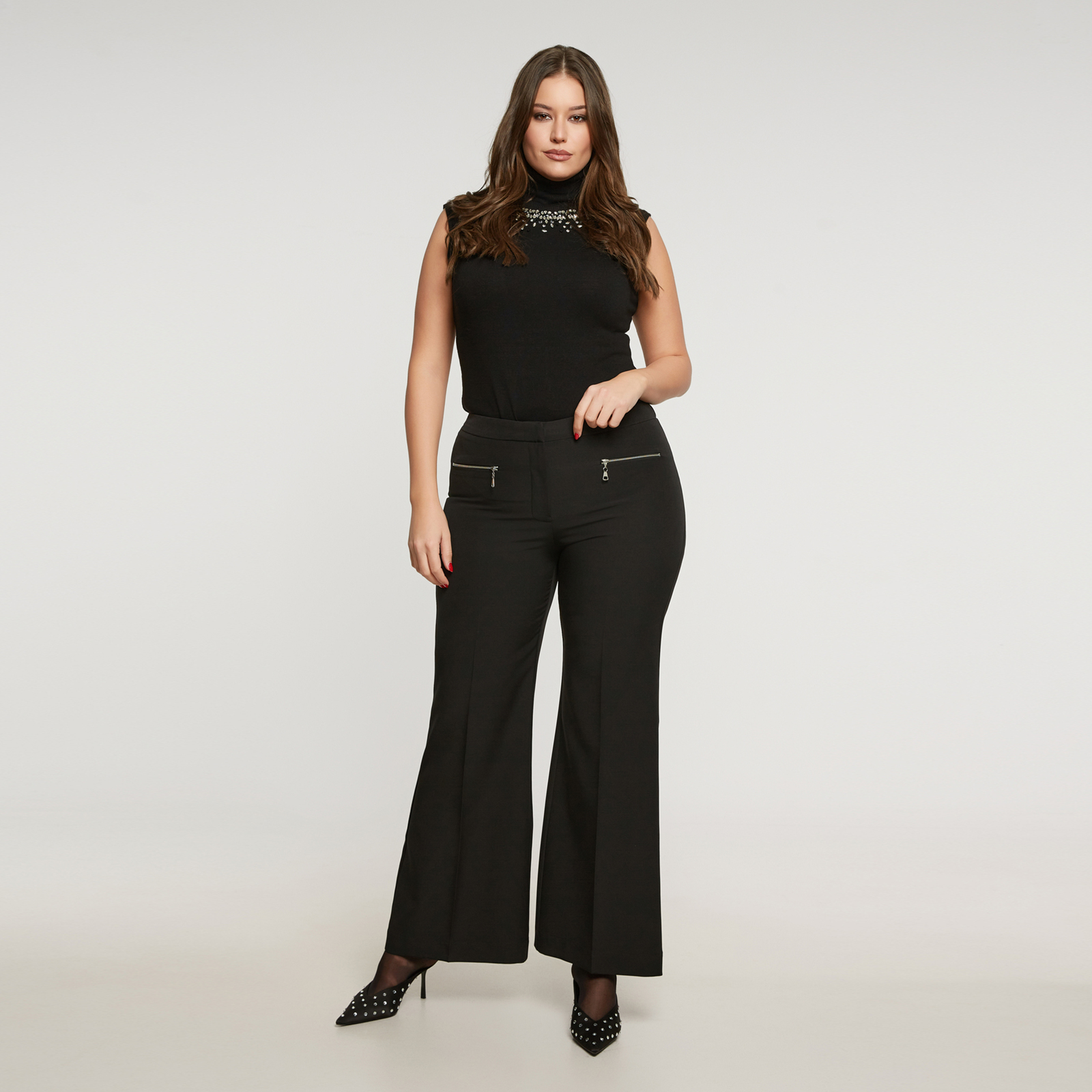 Ένα διαχρονικό κομμάτι με σύγχρονη πινελιά. Το μαύρο παντελόνι σε γραμμή καμπάνα ανανεώνει το κλασικό tailoring με φερμουάρ στους γοφούς και γραμμή που κολακεύει τη σιλουέτα. Από απαλό, ελαστικό ύφασμα κοστουμιού, συνδυάζει άψογα το office look με τη βραδινή κομψότητα. ● Από ελαστικό ύφασμα με λεία και δομημένη υφή ● Γραμμή καμπάνα που κολακεύει και επιμηκύνει τη σιλουέτα ● Διακοσμητικά φερμουάρ στα πλαϊνά για μοντέρνο χαρακτήρα ● Mid-rise καβάλο και καθαρές γραμμές για κομψό αποτέλεσμα ● Άνετο και ευέλικτο — ιδανικό για το γραφείο ή τη βραδινή έξοδο Μήκος (εσωτερική ραφή): 82,5 εκ. 89%POLYESTER 11%ELASTANE Το μοντέλο έχει ύψος 1,80 εκ. και φοράει S Made in Greece 