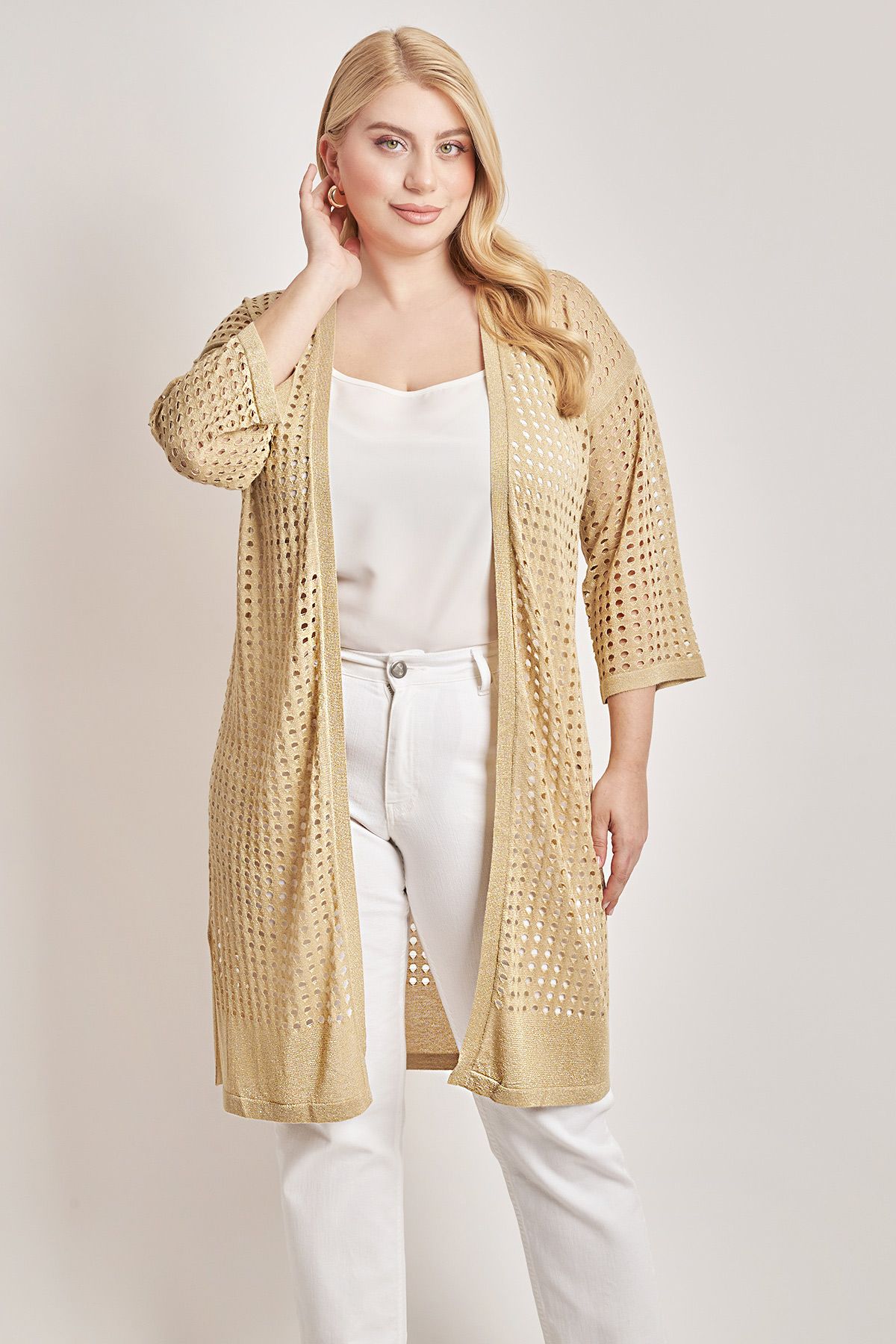 Μακριά ζακέτα χωρίς κούμπωμα σε αραιή πλέξη με σχέδιο δίχτυ. Μανίκια 3/4. Πλαϊνά ανοίγματα. Το μοντέλο έχει ύψος 177εκ, στήθος 105, μέση 88, περιφέρεια 110 και φοράει μέγεθος S