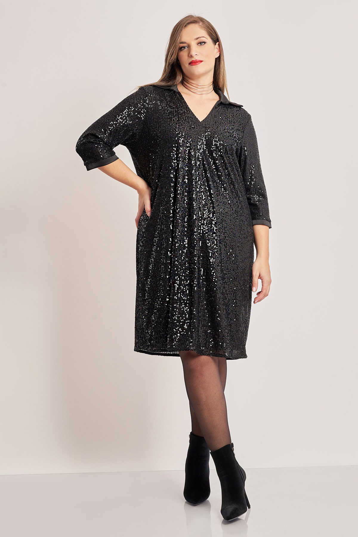 Μίντι φόρεμα με παγιέτες. V λαιμόκοψη με γιακά σατινέ. Μανίκια 3/4 με σατινέ τελείωμα. Σε ριχτή γραμμή με κουφόπιετα μπροστά. Με φόδρα. Το μοντέλο έχει ύψος 180 εκ, στήθος 107, μέση 95, περιφέρεια 122 και φοράει το μέγεθος S