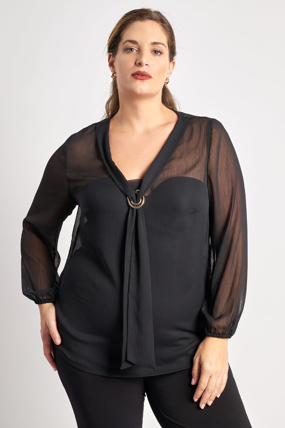 Μπλούζα μονόχρωμη chiffon ημιδιάφανη. Μακριά μανίκια με ελαστική μανσέτα. Δετή γραβάτα στον λαιμό με διακόσμητικό. Δώστε έμφαση στη θηλυκή κομψότητα με αυτή τη μπλούζα. Διατίθεται χωρίς το εσωτερικό τοπ με τιράντες που φοράει το μοντέλο στις προϊοντικές φωτογραφίες. Το μοντέλο έχει ύψος 180 εκ, στήθος 107, μέση 95, περιφέρεια 122 και φοράει το μέγεθος S