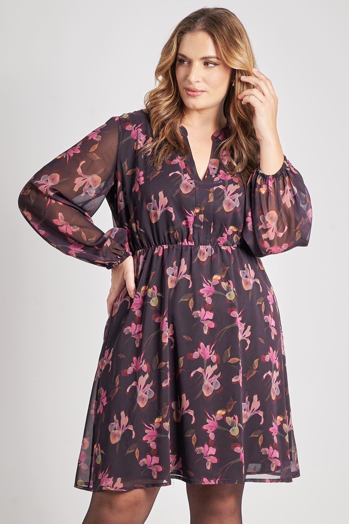 Αυτό το κομψό φόρεμα σε μήκος πάνω από το γόνατο είναι ιδανικό για smart-casual και ρομαντικές εμφανίσεις. Είναι κατασκευασμένο από ανάλαφρο σιφόν ύφασμα. Διαθέτει V-λαιμόκοψη με μικρό γιακά, μακριά μανίκια με σούρες και ελαστική μέση, προσδίδοντας κίνηση και κολακευτική εφαρμογή. Έχει φόδρα στο κυρίως μέρος. Συνδυάστε το με μαύρο οπάκ καλσόν και μποτάκια ή γόβες. Προσθέστε ένα ζεστό παλτό ή σακάκι για τις πιο κρύες μέρες. Το μοντέλο έχει ύψος 180 εκ στήθος 107 μέση 95 περιφέρεια 122 και φοράει το μέγεθος S