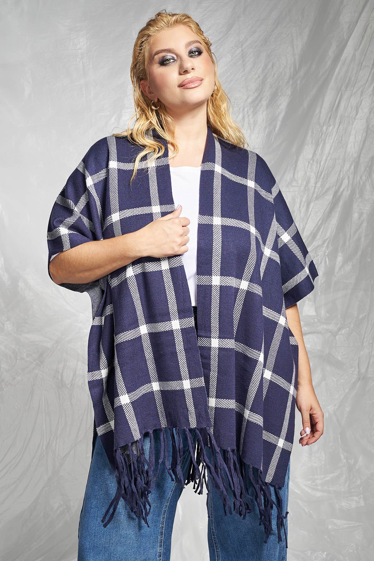 Μια ζεστή και άνετη πλεκτή κάπα με oversized γραμμή που τυλίγεται γύρω από το σώμα, ιδανική για layering. Το κυρίαρχο καρό μοτίβο της αποτελεί μια κλασική επιλογή, ενώ τα μακριά κρόσσια στο τελείωμα προσθέτουν μια boho και παιχνιδιάρικη διάθεση. Λειτουργεί ως ελαφρύ πανωφόρι ή αξεσουάρ, προσφέροντας άμεσο στυλ και έξτρα ζεστασιά. Για ένα casual στυλ, φορέστε την κάπα πάνω από ένα μονόχρωμο ζιβάγκο ή ένα απλό top, συνδυασμένο με ίσια τζιν παντελόνια ή δερμάτινο κολάν. Ολοκληρώστε με flat μπότες ιππασίας ή μποτάκια τύπου Chelsea. Διατίθεται σε 2 μεγέθη. Το μοντέλο έχει ύψος 177εκ στήθος 110 μέση 85 περιφέρεια 115 και φοράει μέγεθος M