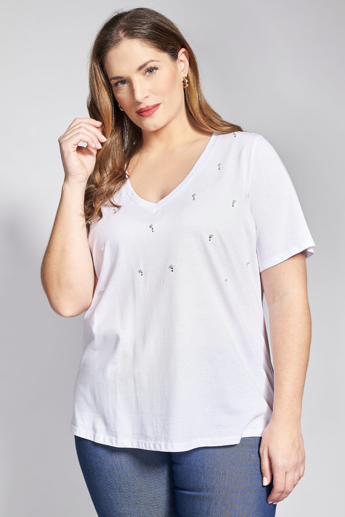 Αυτό το T-shirt μεταμορφώνει ένα βασικό κομμάτι σε ένα μικρό έργο τέχνης. Η κατασκευή του από 100% ποιοτικό βαμβακερό ύφασμα εξασφαλίζει την απαραίτητη απαλότητα και αναπνευσιμότητα, ενώ το σχέδιο αναβαθμίζεται θεαματικά από τον περίτεχνο στολισμό με λαμπερά strass και διακριτικές πέρλες. Οι λεπτομέρειες αυτές είναι τοποθετημένες με τρόπο που αντανακλά το φως σε κάθε σας κίνηση, προσθέτοντας μια δόση glamour χωρίς να χάνεται ο cool χαρακτήρας του ρούχου. Η γραμμή του είναι κανονική και άνετη, με στρογγυλή λαιμόκοψη και κοντά μανίκια, προσφέροντας την ιδανική βάση για να αναδειχθούν οι διακοσμητικές λεπτομέρειες. Casual look: Συνδυάστε το με ένα φθαρμένο denim παντελόνι και λευκά sneakers για να δημιουργήσετε μια ενδιαφέρουσα αντίθεση ανάμεσα στο casual και το glam στυλ. Office look: Φορέστε το μέσα από ένα δομημένο blazer με ένα υφασμάτινο παντελόνι σε ίσια γραμμή, αφήνοντας τον στολισμό να φανεί διακριτικά ως εναλλακτική λύση αντί για κόσμημα. Evening look: Αναδείξτε το συνδυάζοντάς το με μια ψηλόμεση δερμάτινη φούστα ή μια satin παντελόνα και ψηλοτάκουνα πέδιλα για μια εντυπωσιακή βραδινή έξοδο που εκπέμπει ανεπιτήδευτη κομψότητα. Το μοντέλο έχει ύψος 180 εκ στήθος 107 μέση 95 περιφέρεια 122 και φοράει το μέγεθος S