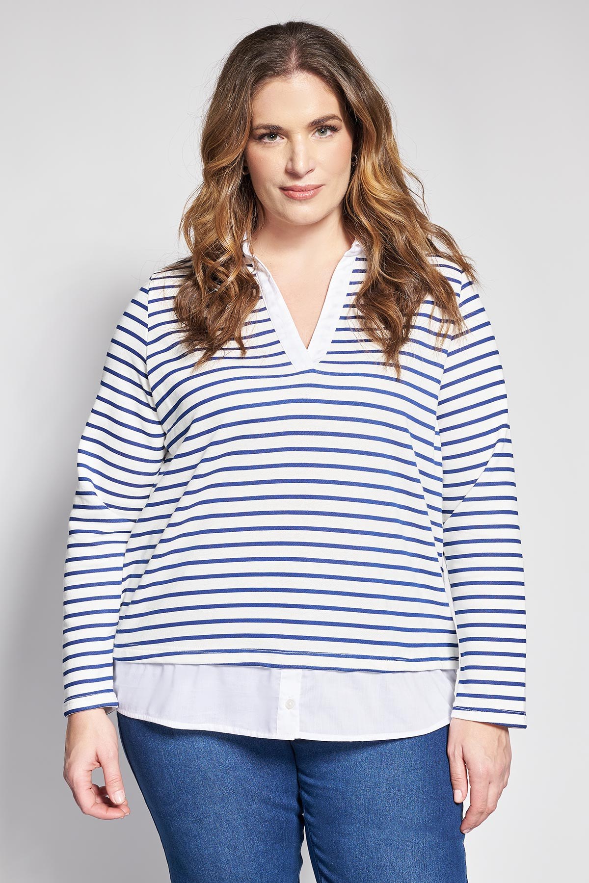 Αυτή η μπλούζα από υψηλής ποιότητας βαμβακερό φούτερ, συνδυάζει την άνεση ενός κλασικού ριγέ τοπ με την κομψότητα ενός πουκαμίσου, δημιουργώντας ένα έτοιμο layered look που κλέβει τις εντυπώσεις. Διαθέτει διαχρονικές μπλε και λευκές οριζόντιες ρίγες και κολακευτική λαιμόκοψη V με ενσωματωμένο γιακά. Το ιδιαίτερο λευκό τελείωμα πουκαμίσου στο κάτω μέρος προσθέτει μια προσεγμένη λεπτομέρεια που αναβαθμίζει το καθημερινό στυλ, καθιστώντας την ιδανική επιλογή για το γραφείο ή τις απογευματινές βόλτες. Συνδυάστε τη με ένα τζιν παντελόνι και λευκά sneakers για μια φρέσκια, casual εμφάνιση, ή με ένα υφασμάτινο παντελόνι για ένα πιο casual chic αποτέλεσμα. Το μοντέλο έχει ύψος 180 εκ στήθος 107 μέση 95 περιφέρεια 122 και φοράει το μέγεθος S
