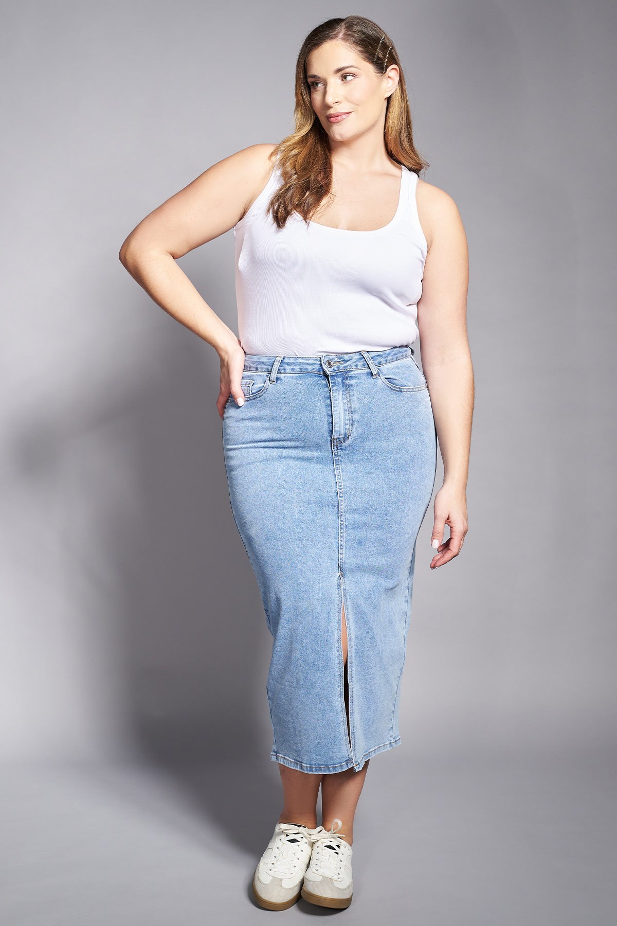 Αυτή η τζιν φούστα σε midi μήκος προσφέρει μια μοντέρνα εκδοχή ενός κλασικού αγαπημένου κομματιού. Είναι σχεδιασμένη σε ίσια γραμμή με ψηλή μέση που κολακεύει τη σιλουέτα, ενώ το μπροστινό σκίσιμο στο κέντρο προσθέτει μια δόση θηλυκότητας και διευκολύνει την κίνηση. Το ανοιχτόχρωμο 