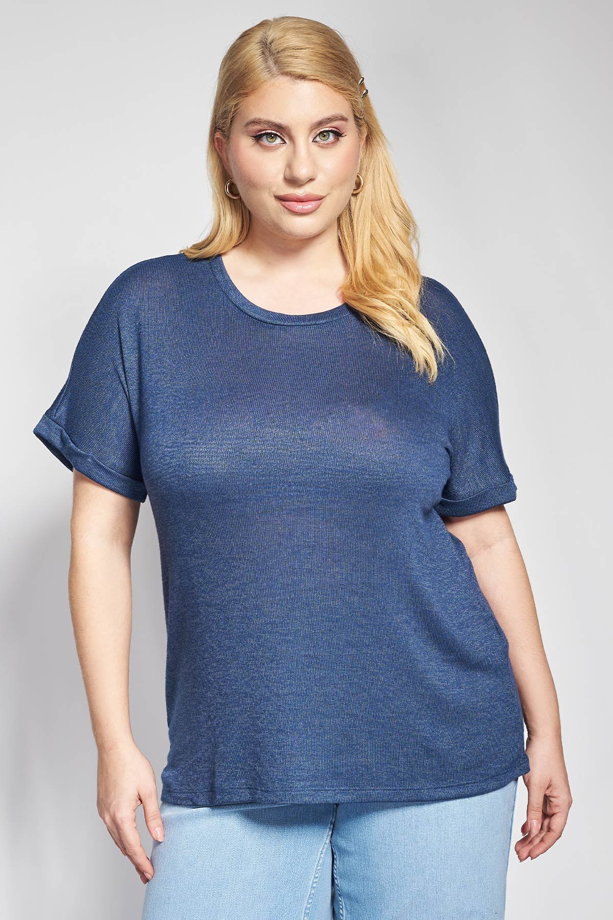 Αυτό το πλεκτό μπλουζάκι σε στυλ Τ-Shirt αποτελεί ένα απαραίτητο κομμάτι για κάθε σύγχρονη γκαρνταρόμπα. Από απαλή και υψηλής ποιότητας πλέξη που προσφέρει εξαιρετική αίσθηση στο δέρμα και αντοχή στον χρόνο. Σε άνετη, ελαφρώς χαλαρή γραμμή του εξασφαλίζει απόλυτη ελευθερία κινήσεων και κολακεύει τη σιλουέτα. Το σχέδιο διακρίνεται για την κλασική στρογγυλή λαιμόκοψη και τα κοντά μανίκια με λεπτομέρεια στο ρεβέρ, στοιχεία που προσδίδουν μια διακριτική πολυτέλεια. Για ένα άψογο Casual Chic look, συνδυάστε το με ένα ψηλόμεσο τζιν παντελόνι και boat shoes, ενώ για το γραφείο μπορείτε να δημιουργήσετε ένα σοφιστικέ Office Look φορώντας το μέσα από ένα σακάκι με υφασμάτινο παντελόνι και loafers. Αν επιθυμείτε μια πιο προσεγμένη απογευματινή εμφάνιση, ταιριάξτε το με μια σατέν midi φούστα, πέδιλα με λουράκια και χρυσούς κρίκους, αναδεικνύοντας τον ευέλικτο χαρακτήρα του που μεταμορφώνεται εύκολα ανάλογα με το styling.Το κύριο υλικό σε αυτό το προϊόν περιέχει τουλάχιστον 50% Βισκόζη - Tangcell™ EcoTang™ μία βιοδιασπώμενη τεχνητή ίνα κυταρρίνης από ξυλοπολτό δέντρων από δάση πιστοποιημένα από το Forest Stewardship Council (FSC), διασφαλίζοντας υπεύθυνη διαχείριση και μειώνοντας τον κίνδυνο αποψίλωσης αρχαίων ή απειλούμενων δασών. Χάρη στη φιλική προς το περιβάλλον παραγωγή του, εξοικονομεί νερό και μειώνει τις περιβαλλοντικές επιπτώσεις.. Το Tangcell™ EcoTang™ είναι πιστοποιημένο και διασφαλίζει ότι δεν περιέχει επιβλαβείς ουσίες.
