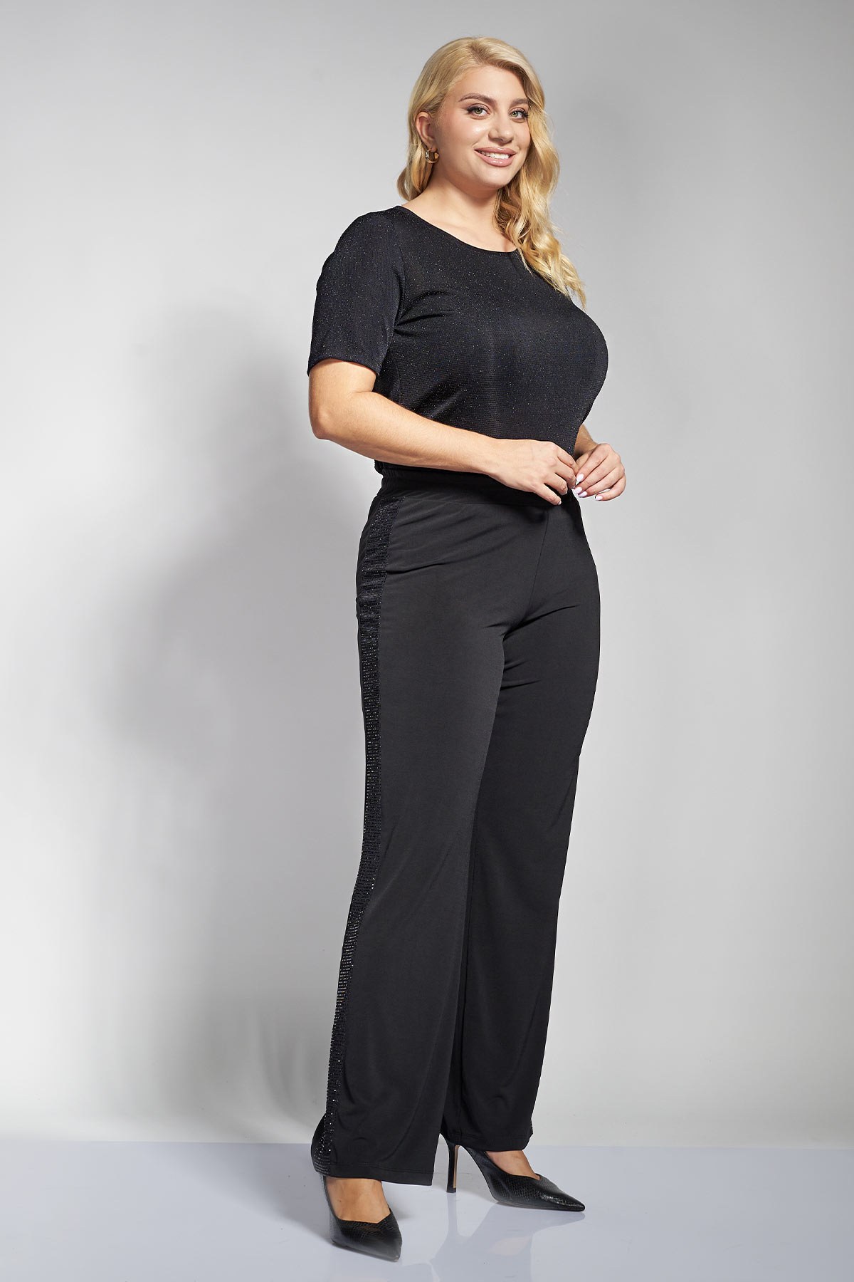 Αυτό το εντυπωσιακό ψηλόμεσο παντελόνι με ίσια γραμμή είναι ιδανικό για βραδινή εμφάνιση και γιορτινό look. Διαθέτει κάθετη λωρίδα με μεταλλική λάμψη σε όλη την επιφάνεια. Η άνετη εφαρμογή του και η ελαστική του μέση το καθιστούν ευκολοφόρετο. Συνδυάστε το με μονόχρωμο σατέν τοπ ή με πλεκτή μπλούζα σε σκούρο χρώμα. Ολοκληρώστε το look με μαύρες γόβες για να αναδείξετε τη λάμψη και τη γραμμή του. Το μοντέλο έχει ύψος 177εκ στήθος 110 μέση 85 περιφέρεια 115 και φοράει μέγεθος S