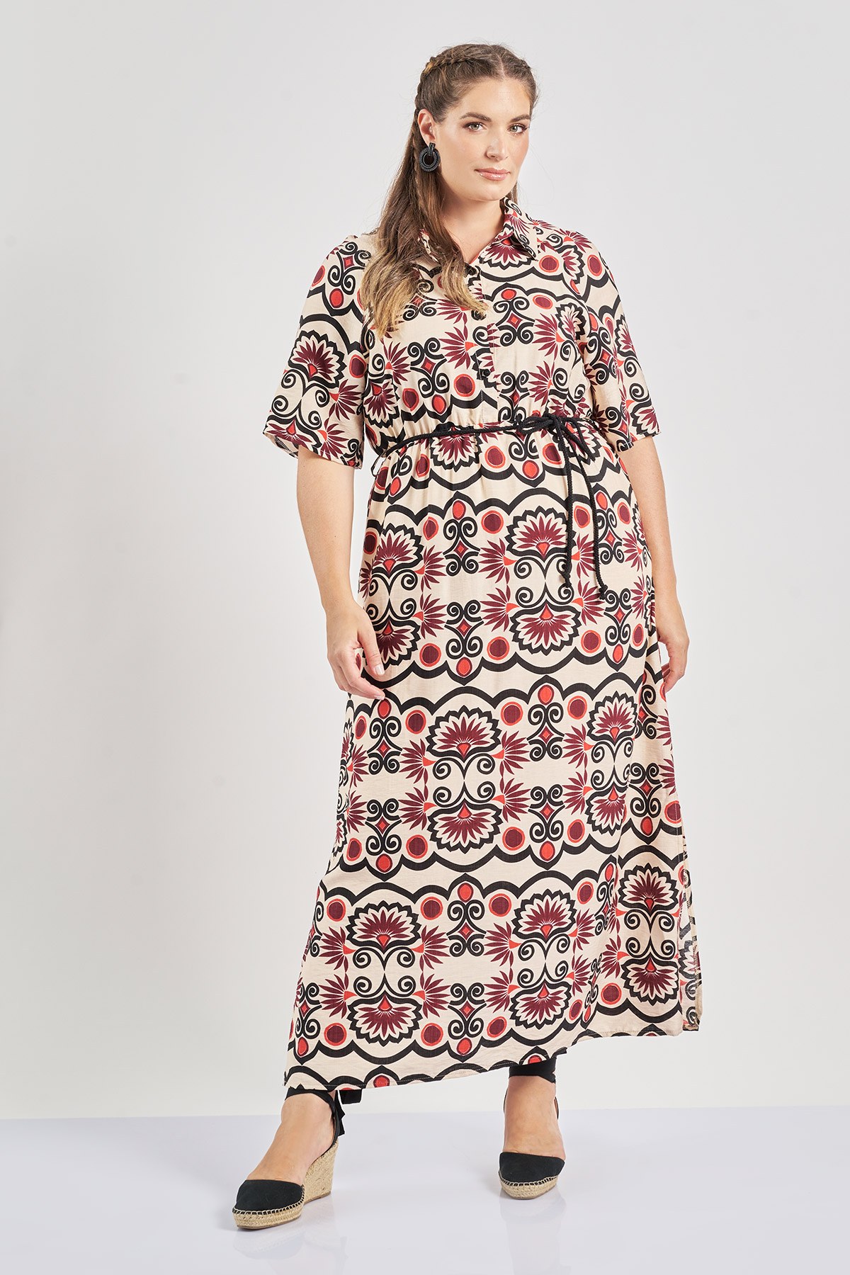 Φόρεμα από ρεγιόν σε boho εμπριμέ. Γιακάς πουκαμίσου και κουμπιά στο στήθος. Κοντά μανίκια και ζώνη στη μέση. Το μοντέλο έχει ύψος 180 εκ, στήθος 107, μέση 95, περιφέρεια 122 και φοράει το μέγεθος S