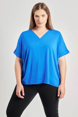 Μπλούζα από ελαστική βισκόζη. Κοντά μανίκια με ρεβέρ στο τελείωμα. Λαιμόκοψη V. Διαθέτει κεντρική κάθετη ραφή στο μπροστινό μέρος. Σε ίσια γραμμή. Το μοντέλο έχει ύψος 180 εκ, στήθος 107, μέση 95, περιφέρεια 122 και φοράει το μέγεθος S