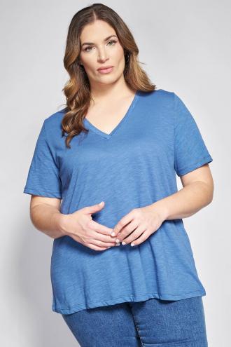 Ανανεώστε την καθημερινή σας γκαρνταρόμπα με ένα κομμάτι που συνδυάζει την απόλυτη άνεση με μια αέρινη, θηλυκή κίνηση. Η κατασκευή της από βαμβακερό ύφασμα φλάμα χαρίζει μια ιδιαίτερη ανάγλυφη υφή και εξαιρετική αναπνευσιμότητα, κάνοντάς την ιδανική για τις ζεστές ημέρες. Διαθέτει κομψή V λαιμόκοψη και άνετα κοντά μανίκια που προσφέρουν ελευθερία κινήσεων και δροσερή αίσθηση. Σε γραμμή-A που χαρίζει άνεση στην περιοχή της περιφέρειας και κολακεύει κάθε σιλουέτα. Casual look: Συνδυάστε τη με ένα denim παντελόνι ή ένα κολάν και τα αγαπημένα σας sneakers για ένα χαλαρό πρωινό σύνολο. Office look: Ταίριαξέ τη μέσα από ένα μεσάτο blazer με ένα υφασμάτινο παντελόνι σε ίσια γραμμή και minimal loafers για μια άνετη αλλά επαγγελματική εμφάνιση. Το μοντέλο έχει ύψος 180 εκ στήθος 107 μέση 95 περιφέρεια 122 και φοράει το μέγεθος S