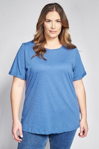 Ανανεώστε τα καθημερινά σας βασικά κομμάτια με μια μπλούζα που προσφέρει τον απόλυτο συνδυασμό άνεσης και ανεπιτήδευτου στυλ. Η κατασκευή της από ποιοτικό βαμβακερό ύφασμα φλάμα χαρίζει μια μοναδική, ελαφρώς ανάγλυφη υφή που αφήνει το δέρμα να αναπνέει ευχάριστα. Το σχέδιο διακρίνεται για την ανοιχτή στρογγυλή λαιμόκοψη και τα άνετα κοντά μανίκια που εξασφαλίζουν πλήρη ελευθερία κινήσεων σε κάθε δραστηριότητα. Η γραμμή της είναι άνετη, προσφέροντας μια εφαρμογή που αγκαλιάζει απαλά τη σιλουέτα χωρίς να πιέζει, διατηρώντας το σχήμα της όλη μέρα. Στα επιπλέον χαρακτηριστικά της, το στρογγυλεμένο ελείωμα που εγγυάται μία άκρως κομψή εφαρμογή για κάθε σωματότυπο. Casual look: Συνδυάστε τη με ένα denim παντελόνι και sneakers ή flat μπαλαρίνες για μια χαλαρή βόλτα ή τις δουλειές στην πόλη. Office look: Φορέστε τη μέσα από ένα δομημένο blazer με ένα υφασμάτινο παντελόνι και loafers για ένα look που ισορροπεί τέλεια ανάμεσα στο casual και το επαγγελματικό. Το μοντέλο έχει ύψος 180 εκ στήθος 107 μέση 95 περιφέρεια 122 και φοράει το μέγεθος S