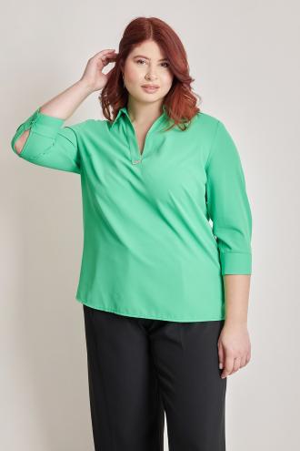 Μονόχρωμη μπλούζα με V. Γιακάς πουκαμίσου και διακόσμηση στο V. Μανίκια 3/4 με κουμπί. Το μοντέλο έχει ύψος 180 εκ, στήθος 106, μέση 88, περιφέρεια 117 και φοράει το μέγεθος S