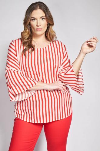 Δημιουργήστε ένα σύγχρονο και δυναμικό look με μια μπλούζα που παίζει με τις γεωμετρίες και τις αναλογίες, προσφέροντας μια φρέσκια ματιά στο κλασικό ριγέ μοτίβο. Από ποιοτική ποπλίνα εξασφαλίζει τη χαρακτηριστική δροσερή αίσθηση και τη σταθερή δομή που απαιτεί ένα statement κομμάτι. Ο συνδυασμός ριγέ σε κάθετη διάταξη δημιουργεί ένα ενδιαφέρον οπτικό εφέ που κολακεύει τη σιλουέτα. Τα άνετα μανίκια 3/4 ολοκληρώνονται με βολάν, προσθέτοντας όγκο και κίνηση, ενώ το μακρύ μήκος με την ασύμμετρη μακρύτερη πλάτη προσδίδει έναν αέρα ανεπιτήδευτης πολυτέλειας και μοντέρνας κάλυψης. Modern City look: Συνδυάστε τη με ένα στενό λευκό παντελόνι και loafers, αφήνοντας την ασυμμετρία της πλάτης να αναδείξει τη σιλουέτα σας με έναν ιδιαίτερο τρόπο. Chic look: Φορέστε τη με μια midi pencil φούστα και ψηλοτάκουνα πέδιλα, προσθέτοντας μια ζώνη στη μέση για να δώσετε σχήμα στον όγκο της ποπλίνας. Casual look: Ταιριάξτε τη με το αγαπημένο σας denim και sneakers, αναδεικνύοντας τη στρογγυλή λαιμόκοψη με ένα μίνιμαλ κολιέ για ένα καθημερινό σύνολο με χαρακτήρα. Το μοντέλο έχει ύψος 180 εκ στήθος 107 μέση 95 περιφέρεια 122 και φοράει το μέγεθος S